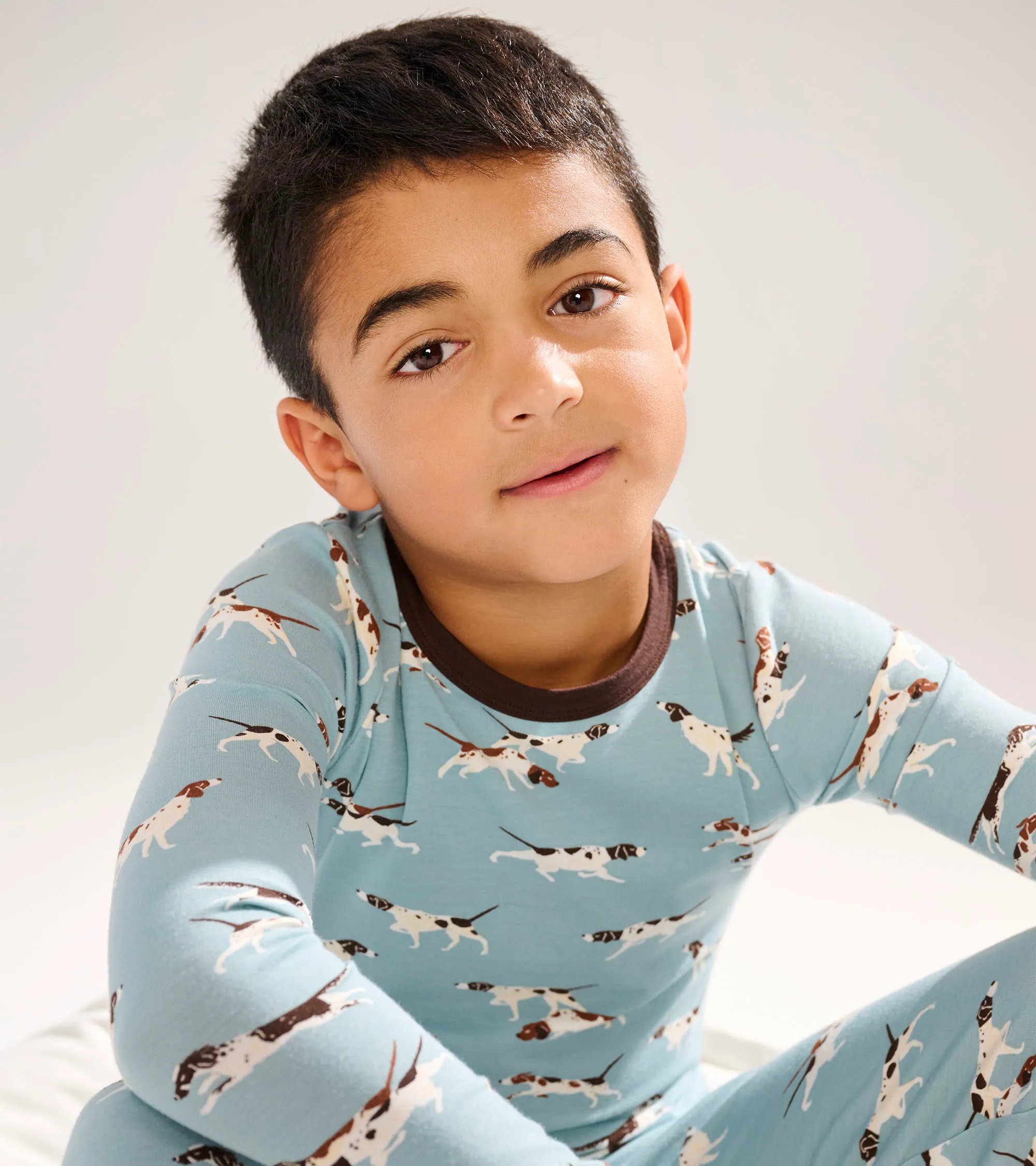 Children in colorful patterned pajamas with animal designs including giraffe print. Fun sleepwear for kids in vibrant colors.