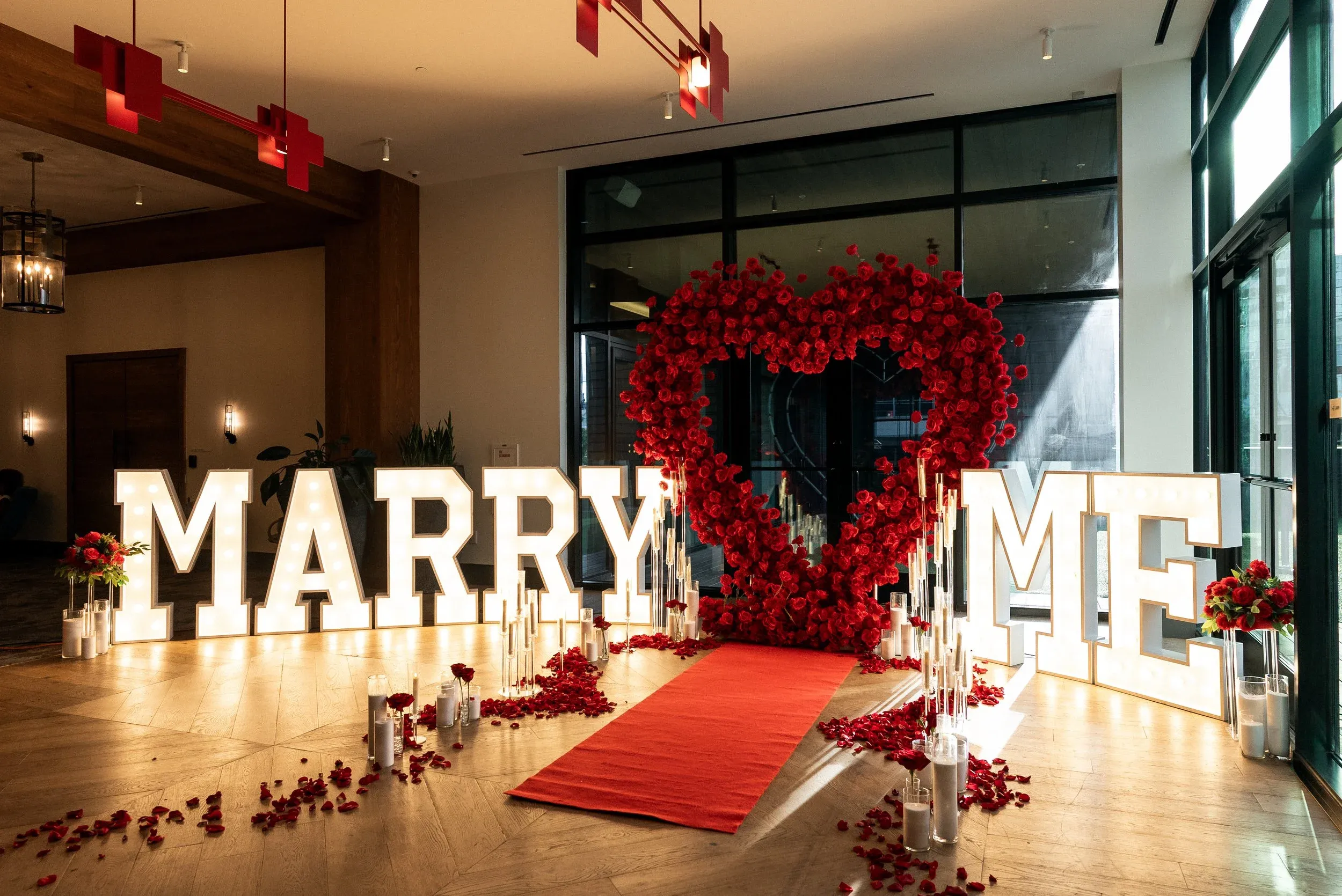 Romantic proposal setting with rose petals, candles and decorations in an intimate space. No human shapes.