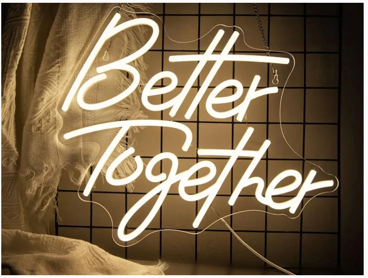 Custom neon sign glowing with romantic text against a dark background. No human shapes.