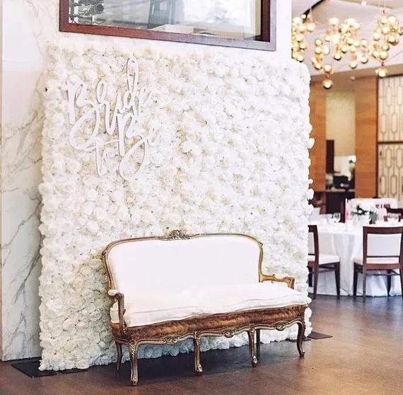 Lush flower wall with mixed roses and greenery arranged in an elegant pattern. No human shapes.