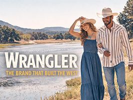 Wrangler western wear for men and women walking along river in Nebraska countryside wearing denim jeans, western shirt, cowboy hat and boots.