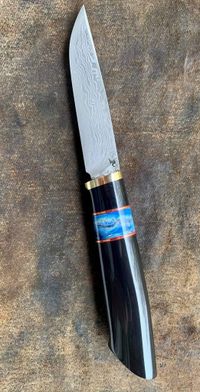 stabilized mammoth tooth in blue spacer on knife