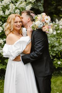 Bukiet ślubny w pastelowych kolorach trzymany przez parę młodą, lekka, naturalna aranżacja