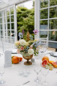 Niska kompozycja kwiatowa na stole gości – kwiaty polne w pastelowych kolorach