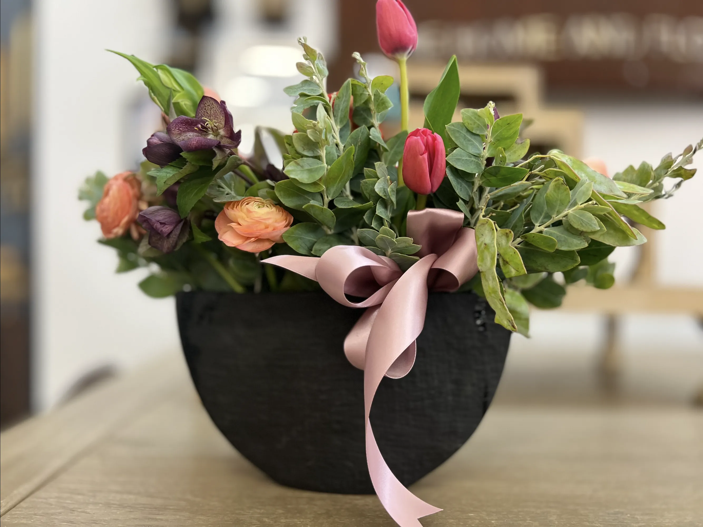 Elegant floral arrangement with seasonal blooms in a decorative vase against neutral background. No human shapes.