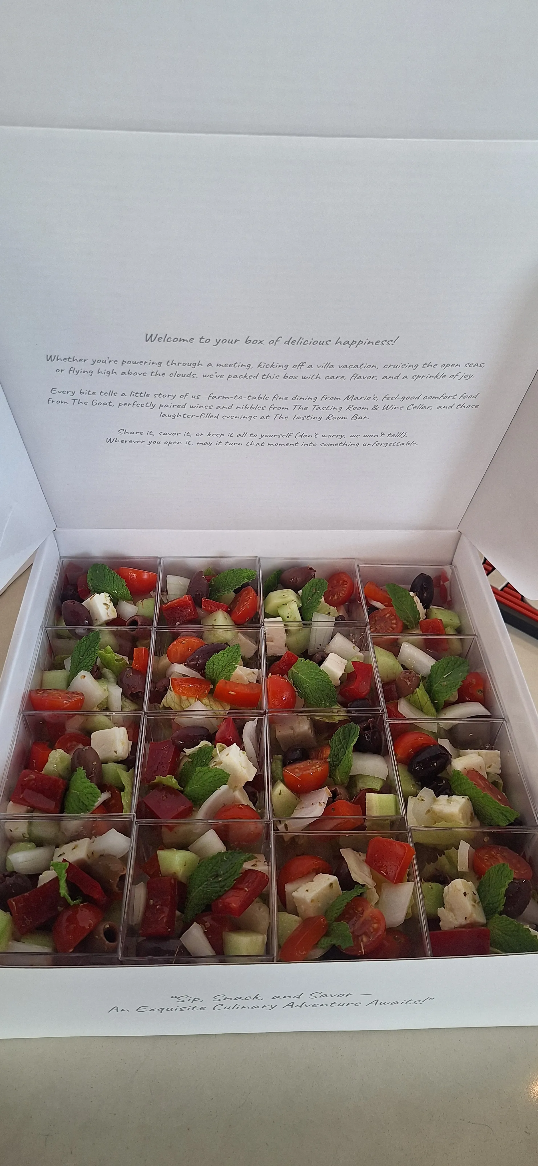 A grazing box filled with individual Greek salad cups