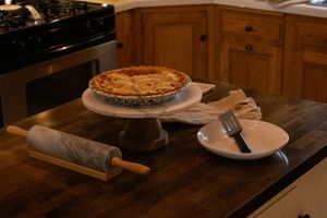 Baked apple pie in pan on wooden counter.