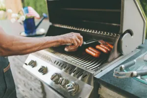 Man grilling hot dogs.