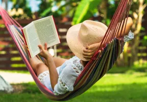 Woman reading a book in a hammock