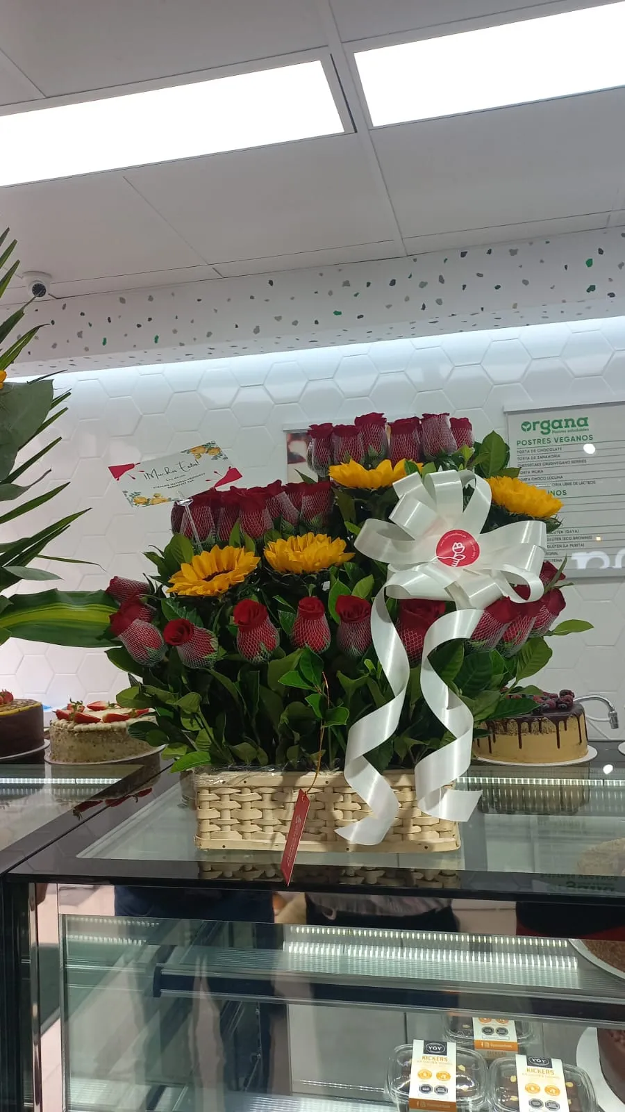 Arreglo floral de rosas rojas y girasoles de MERCADO FLORES en cesto de mimbre, entregado para inauguración en San Borja, Lima