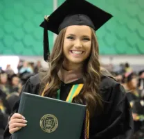 A student with graduation diploma on her hand.