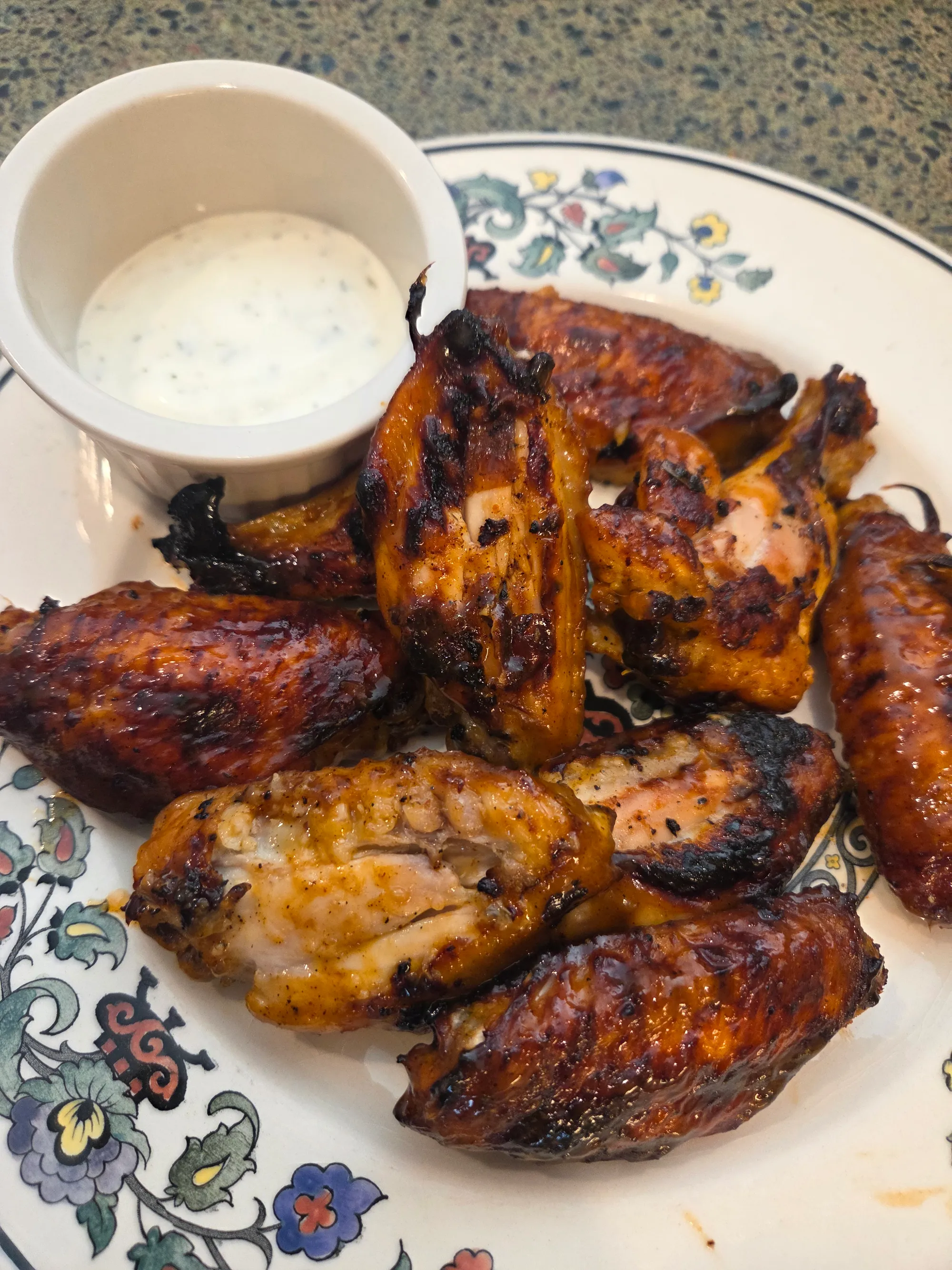 Delicious basket of crispy buffalo wings with a bottle of Hoppy Buffalo Sauce nearby, showing golden-brown wings glistening with tangy red sauce, no human shapes