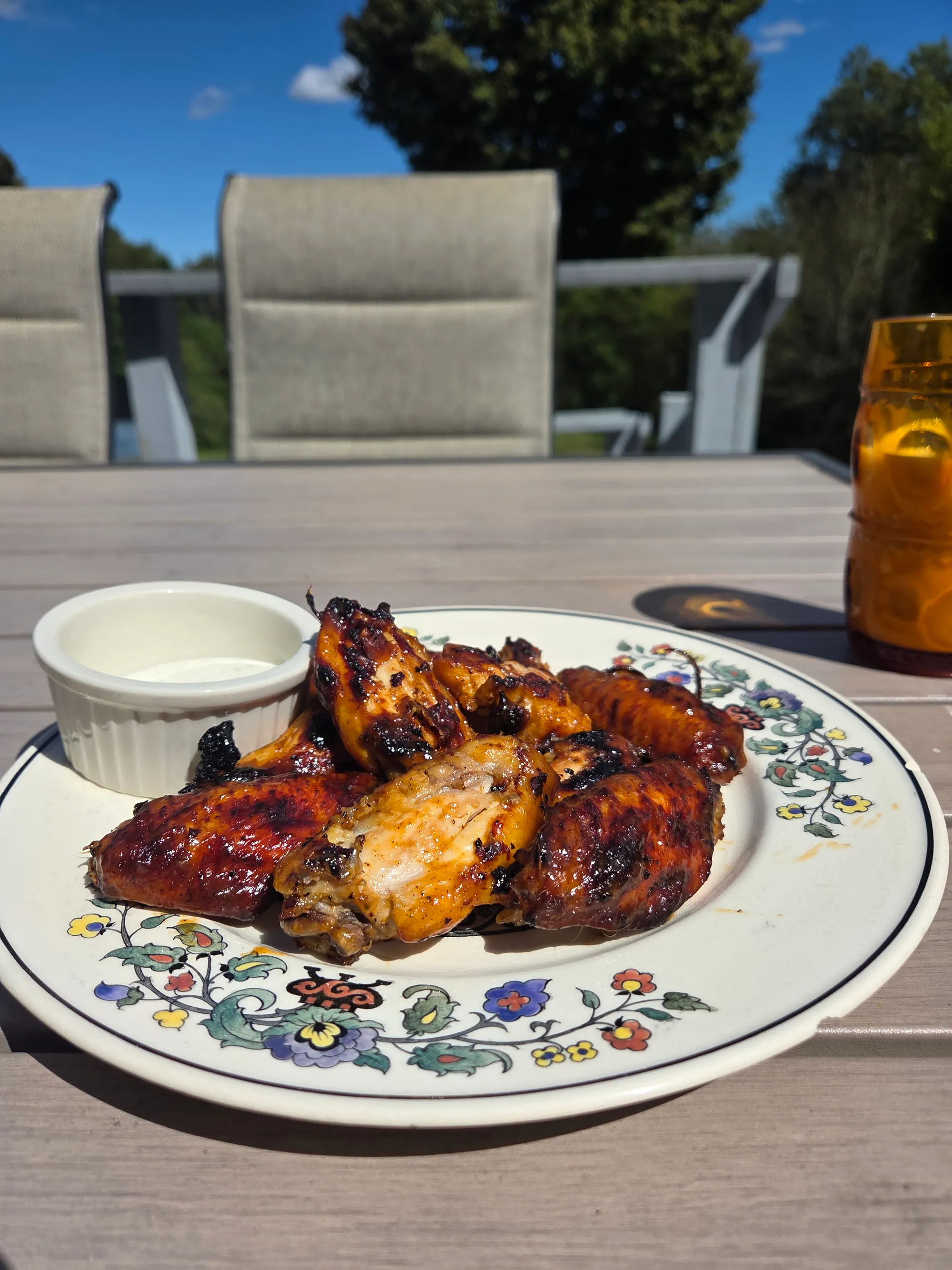Final plated wings piled high on a serving platter with celery and carrot sticks, a bottle of Hoppy Buffalo Sauce visible in the frame, no human shapes