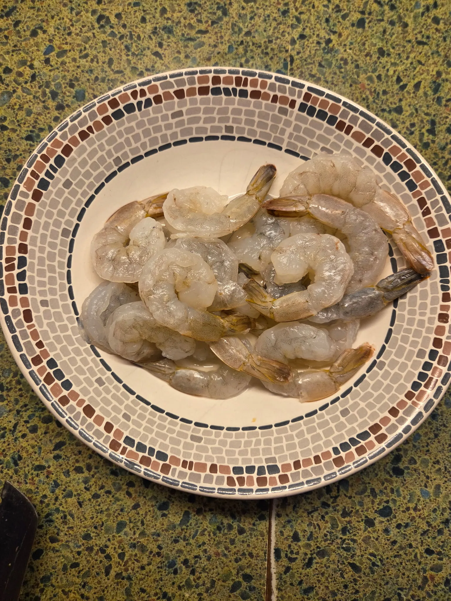 Raw peeled and deveined shrimp in a mixing bowl, glistening with a coating of red-orange Hoppy Sweet Heat sauce. Do not generate human shapes.