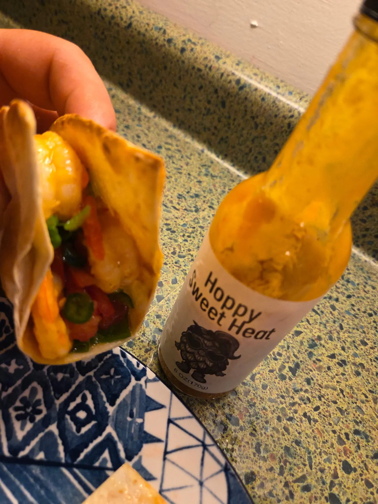 Final plated crispy shrimp tacos on a serving plate with lime wedges and a small dish of extra Sweet Heat sauce for dipping. Tacos are golden and crisp with colorful filling visible. Do not generate human shapes.