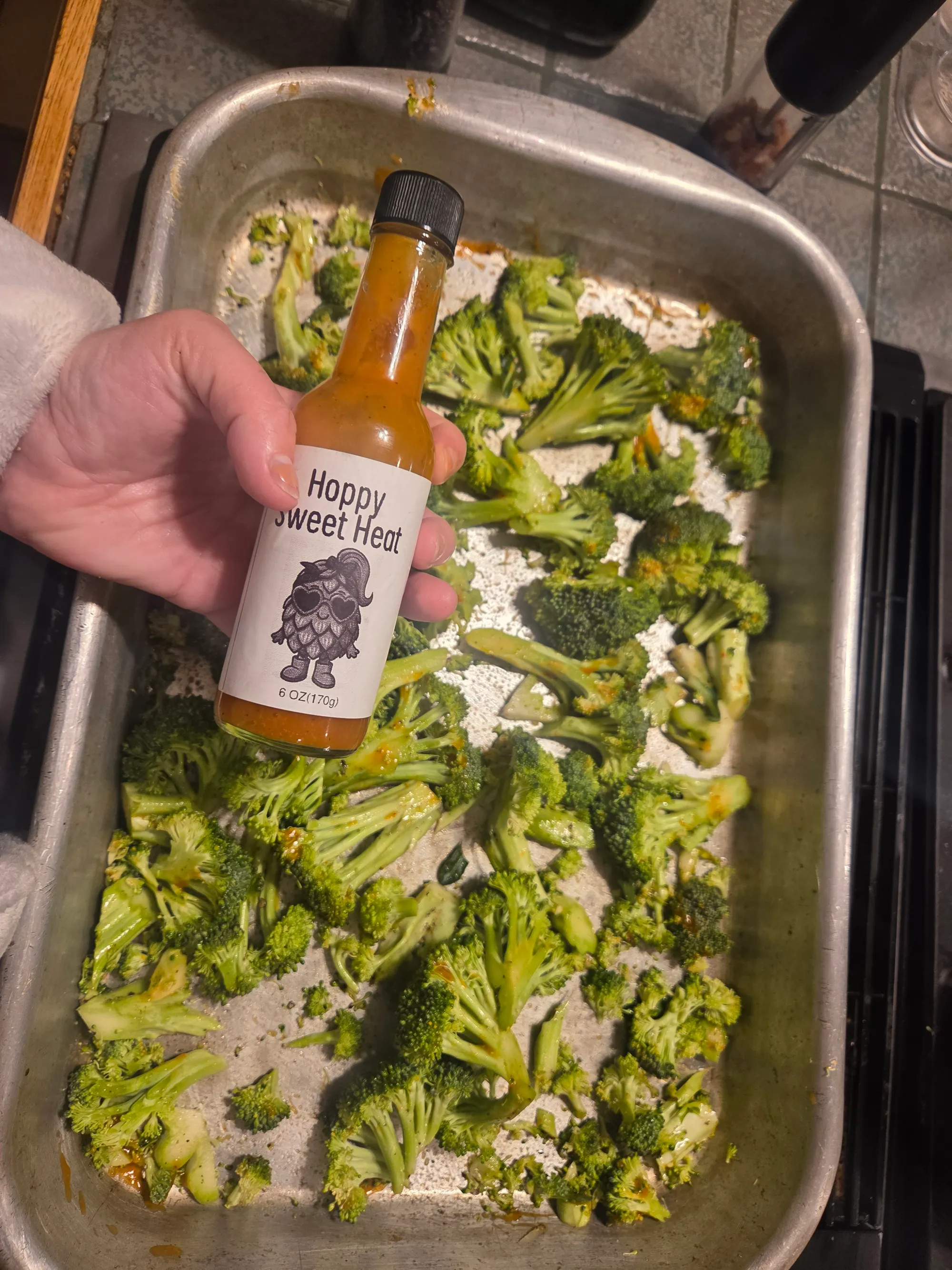 Broccoli florets seasoned with olive oil, salt and pepper on a baking sheet ready for roasting. No human shapes.
