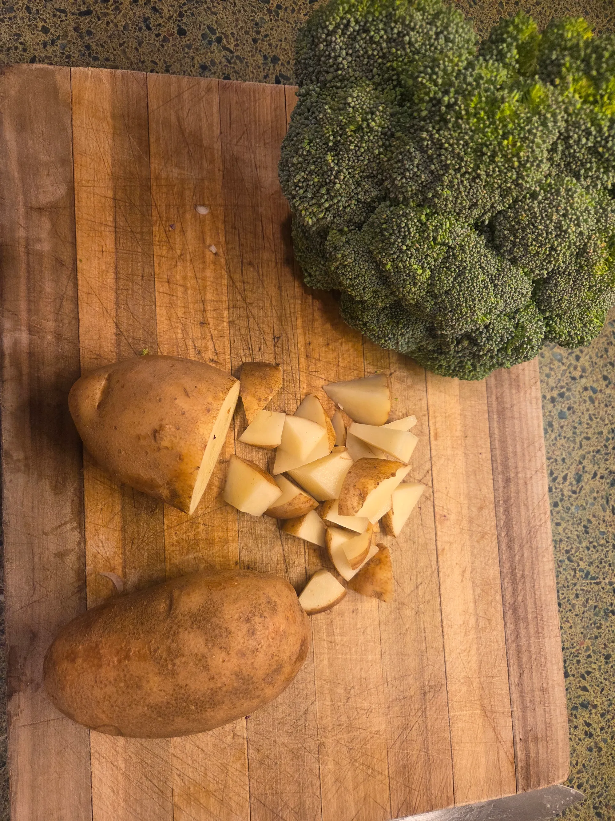 Potatoes being mashed with caramelized onions in a bowl, with butter and cream. No human shapes.